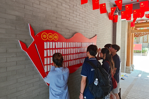 a7cc5f0dd33a4d0aa788ad14dd734ee5.jpg 图片二 团队成员查看游客寄语.jpg